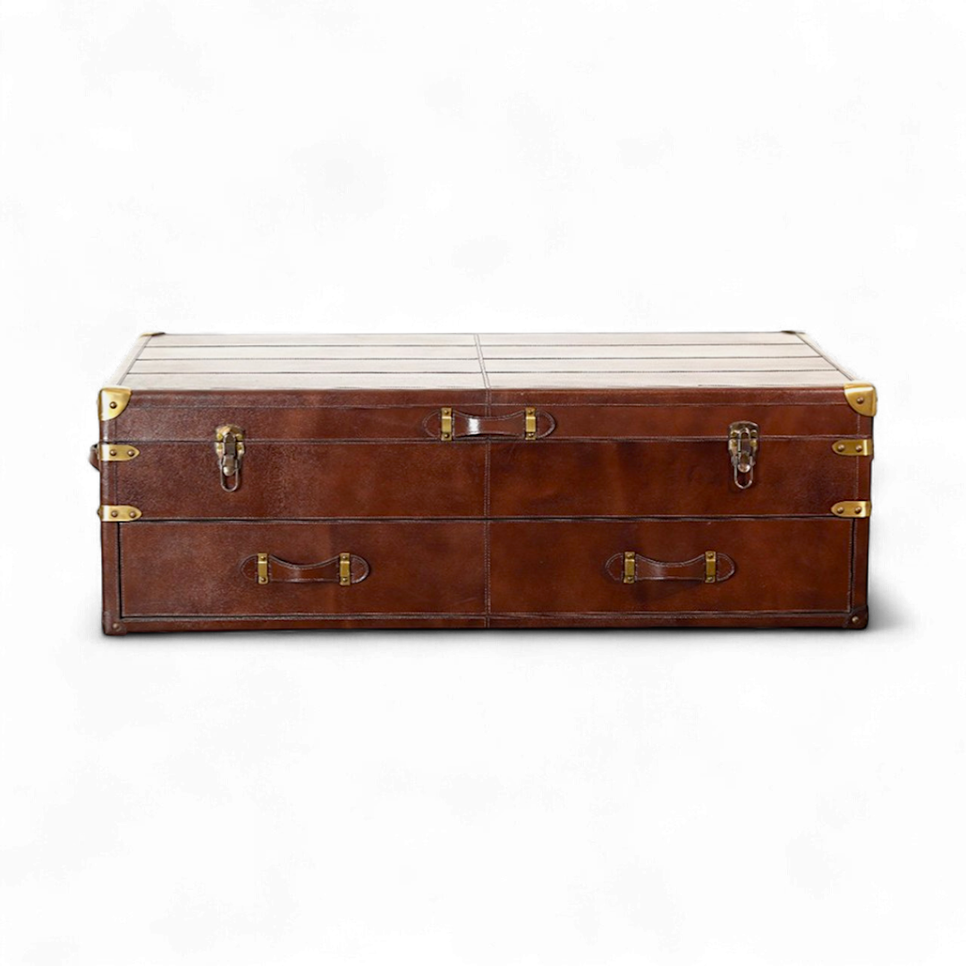 Brown leather trunk center table with gold hardware on a white background
