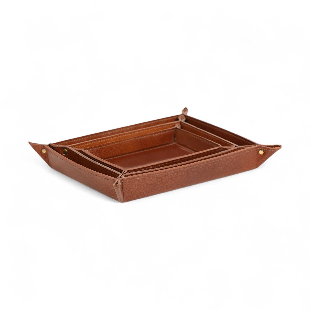 Brown leather tray with gold rivets on a white background