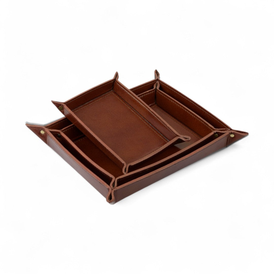Set of brown leather trays on a white background