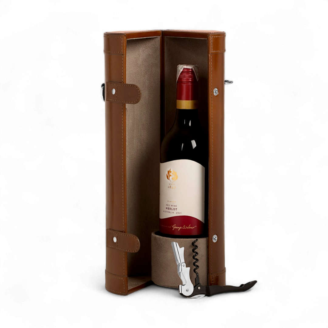 Red wine bottle in a brown leather case with a corkscrew on a white background