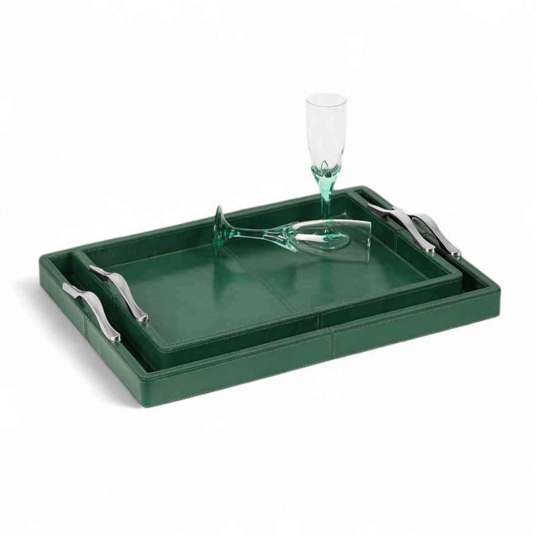 Green tray with silver handles and a glass on a white background