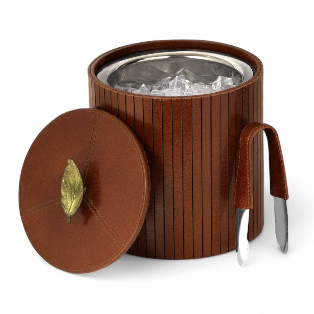 Brown leather ice bucket with silver interior and handle on a white background