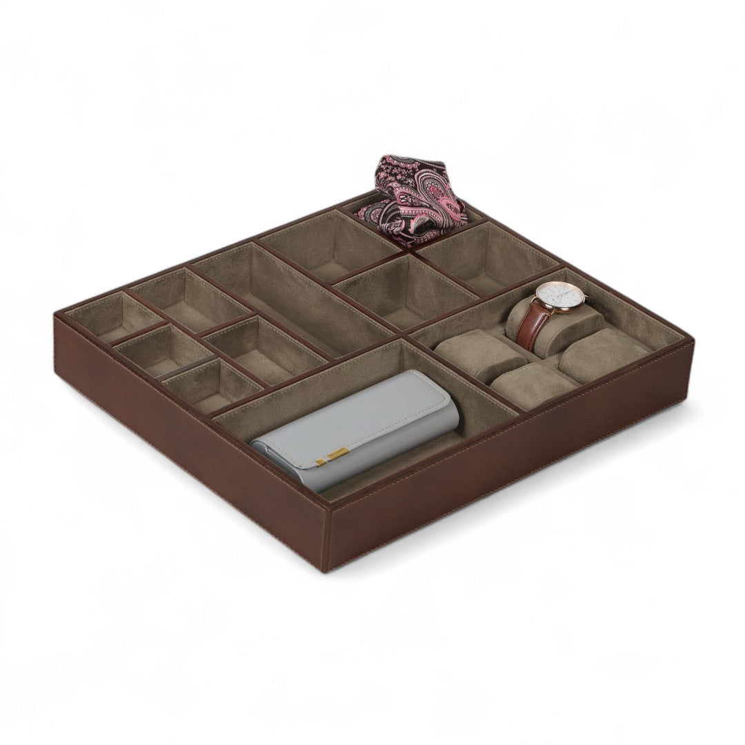Brown jewelry organizer with compartments holding a watch, wallet, and scarf on a white background