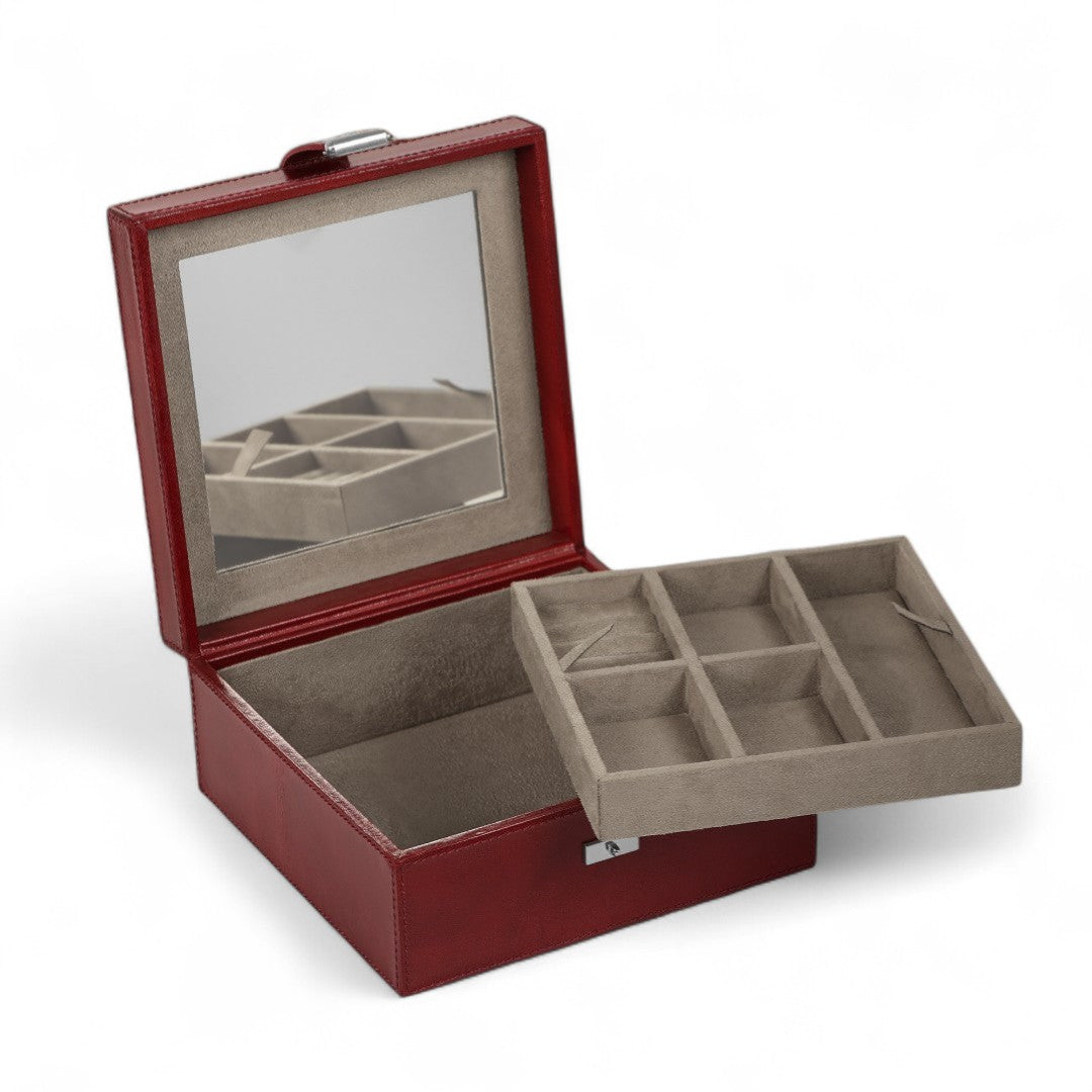 Red jewelry box with open lid showing interior compartments on a white background