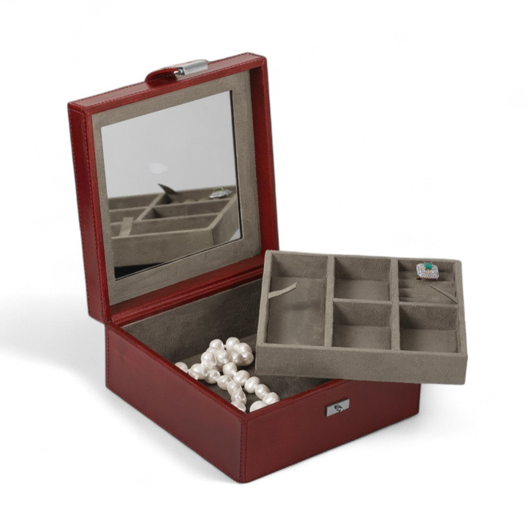 Red jewelry box with a mirror lid, open to reveal compartments and a necklace inside.