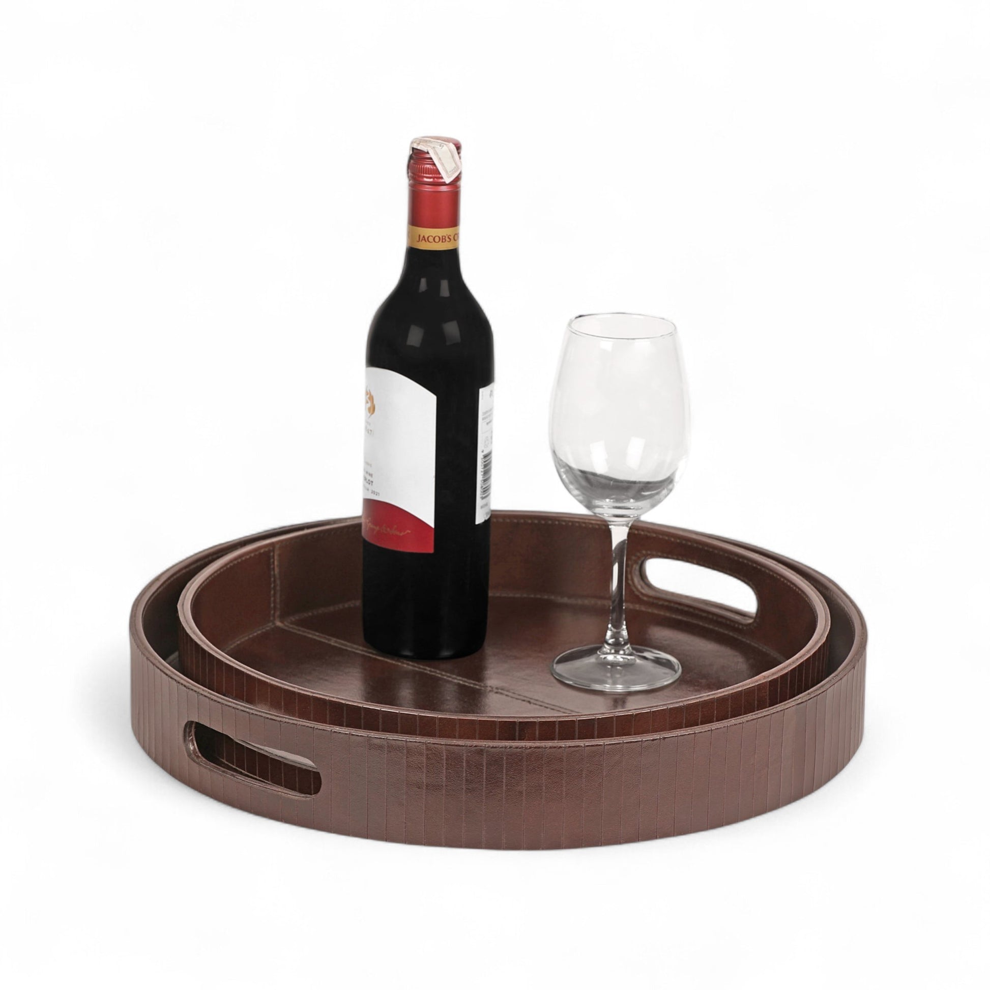 Brown round tray with a bottle of red wine and a glass on a white background