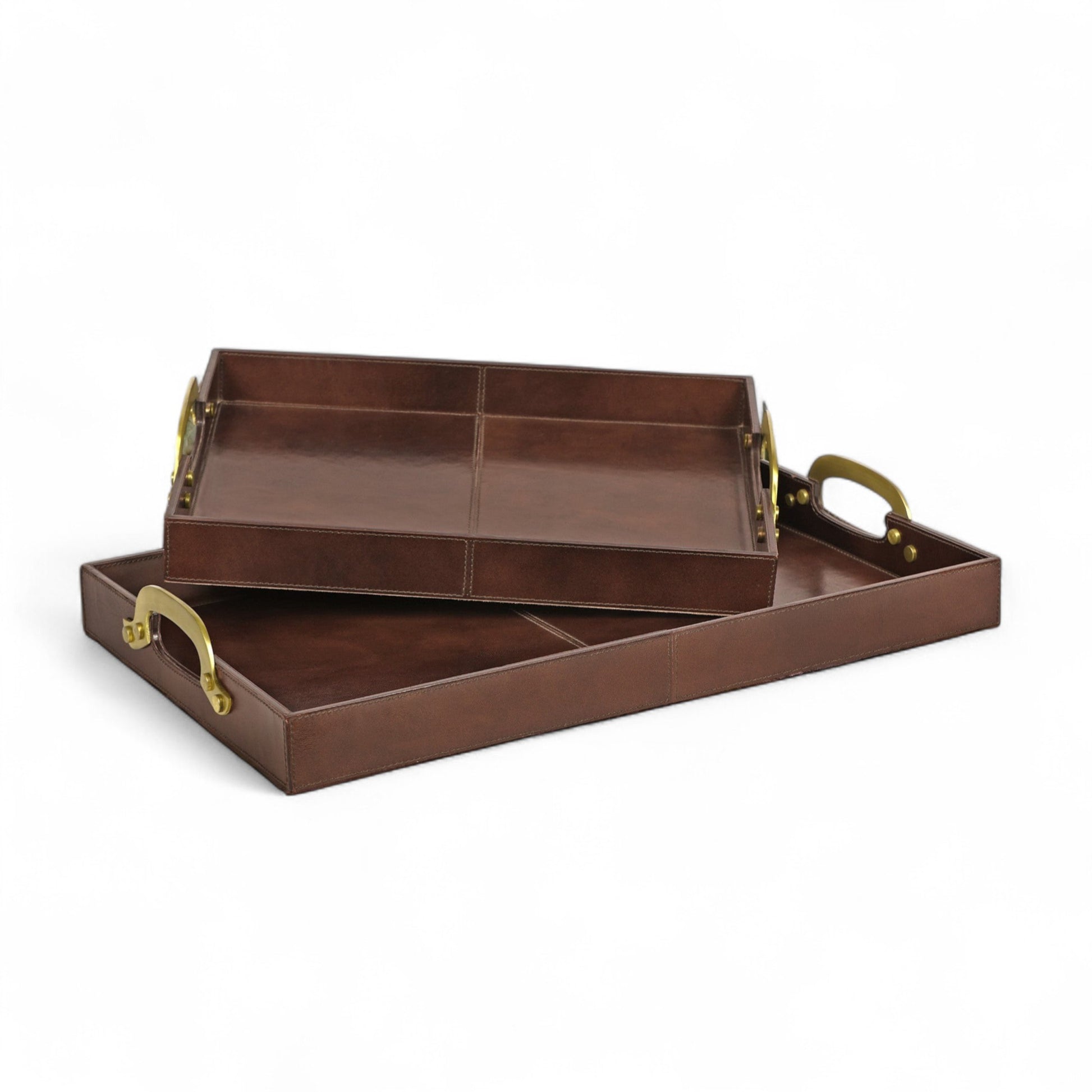 Set of two brown leather trays with gold handles on a white background