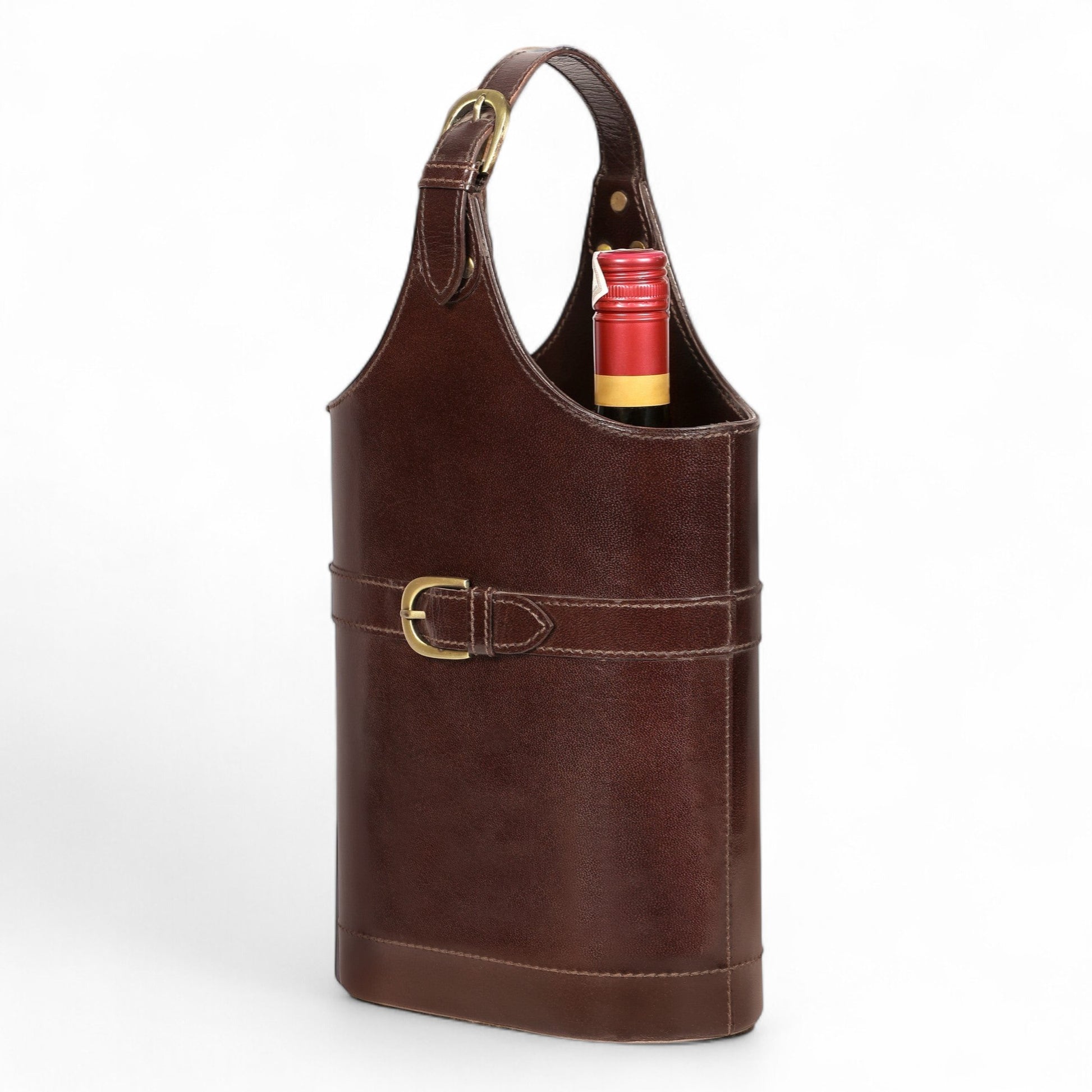 Brown leather wine tote with a gold buckle holding a red wine bottle on a white background
