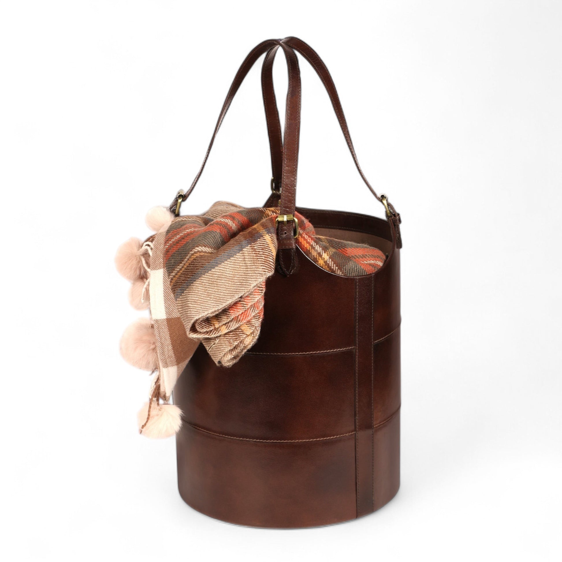 Brown leather bucket bag with a plaid scarf on a white background
