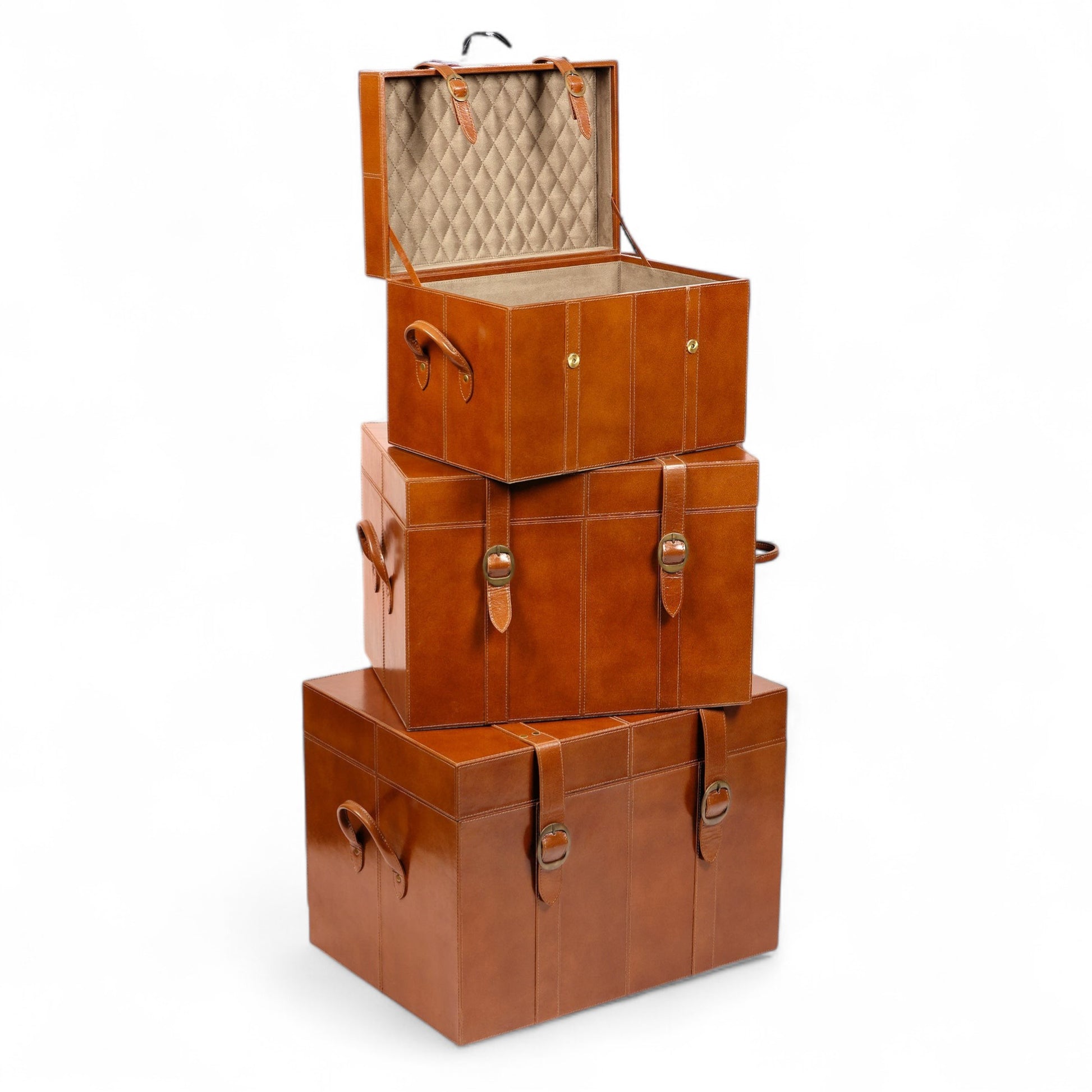 Stack of three brown leather storage trunks on a white background